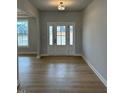 Bright foyer featuring hardwood floors, a large front door with sidelights, and neutral wall colors at 443 Ravensworth Dr, Garner, NC 27529