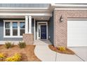 Inviting front entrance with a navy blue door and brick columns at 1527 Peabody Ct, Mebane, NC 27302