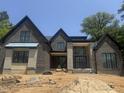 New home construction featuring dark brick, stone accents, and a modern design under a clear blue sky at 504 Colvard Woods Way Way, Durham, NC 27713