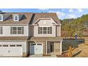 Two-story townhome with gray and beige siding, stone accents, and a two-car garage at 804 Pryor St # 49, Mebane, NC 27302