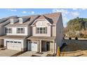 Two-story townhome with gray and beige siding, stone accents, and a two-car garage at 804 Pryor St # 49, Mebane, NC 27302