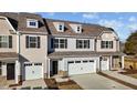 Tan three-story townhome with white garage doors, and landscaping at 806 Pryor St # 50, Mebane, NC 27302