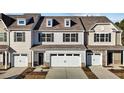 Beige three-story townhome with white garage doors, and landscaping at 806 Pryor St # 50, Mebane, NC 27302