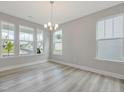 Light-filled dining room with large windows, neutral walls, contemporary chandelier, and beautiful hardwood floors at 236 Alden Way, Angier, NC 27501