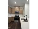 Modern kitchen with stainless steel appliances, light brown cabinets and white countertops plus a black faucet at 1050 Mountain Crown St, Durham, NC 27703