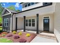 Inviting front porch with black columns and a nicely landscaped flower bed at 6965 Us-401, Fuquay Varina, NC 27526