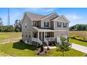Charming two-story home with a front porch, attached garage, and well-maintained landscaping at 15 Diamond Creek Dr, Zebulon, NC 27597