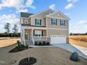 Two-story house with a neutral color scheme, a two-car garage, and a landscaped yard at 15 Diamond Creek Dr, Zebulon, NC 27597