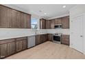 Modern kitchen with dark brown cabinets, white backsplash, and stainless steel appliances at 15 Diamond Creek Dr, Zebulon, NC 27597