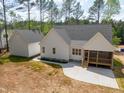 Aerial view showcasing a home's backyard with a screened-in porch, concrete patio, and lush surroundings at 205 Purslane Dr, Franklinton, NC 27525