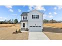 Charming two-story home featuring vinyl siding, black shutters, a welcoming front porch, and an attached garage at 35 Diamond Creek Dr, Zebulon, NC 27597