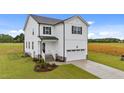 Beautifully landscaped two-story home with white siding, black shutters and door, plus a two-car garage at 35 Diamond Creek Dr, Zebulon, NC 27597