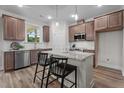 Modern kitchen boasts stainless steel appliances, granite countertops, dark wood cabinets, and an island with seating at 35 Diamond Creek Dr, Zebulon, NC 27597