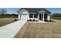 A single story home, featuring a driveway leading to an attached garage, and green space surrounding at 111 Johnson Ridge Way, Four Oaks, NC 27524