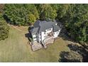 Aerial view of a white house featuring a large deck and patio perfect for outdoor entertaining at 488 Colvard Farms Rd, Durham, NC 27713