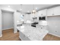 Bright kitchen with white cabinetry, granite countertops, stainless steel appliances, and pendant lighting at 1829 Hydrangea Way, Fuquay Varina, NC 27526