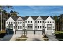 A view of the modern townhome exterior features two-car garages and manicured lawns at 2007 Opulent Oaks Ln # 24, Durham, NC 27713