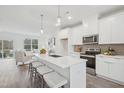 Modern kitchen features white cabinets, stainless steel appliances, and a large island at 2007 Opulent Oaks Ln # 24, Durham, NC 27713
