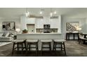 Modern kitchen features white cabinetry, an island with seating, and stainless steel appliances at 2007 Opulent Oaks Ln # 24, Durham, NC 27713