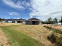 New construction homes with a grassy backyard and clear blue skies in a developing community at 214 Drayton Hall Ln, Sanford, NC 27330