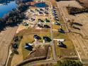 Aerial view of a new construction community with homes and a tranquil pond at 224 Bering Cir, Angier, NC 27501