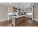 Bright kitchen featuring white cabinets, stainless appliances, quartz countertops, and pendant lights at 25 Firefly Ln, Youngsville, NC 27596