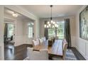 Elegant dining room features a long wooden table with seating for ten, modern lighting, and dark hardwood floors at 111 Demascus Way # 021, Four Oaks, NC 27524