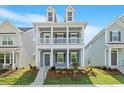 Inviting two-story home with a double-decker porch and beautifully landscaped front yard at 9216 Leaning Post Rd # 447, Wake Forest, NC 27587