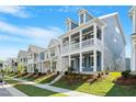 Street view of newly constructed homes, each with inviting front porches and well-maintained landscaping at 9216 Leaning Post Rd # 447, Wake Forest, NC 27587