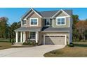 Charming two-story home featuring a stone and siding facade, attached garage and well-manicured landscaping at 120 W Weatherford Dr, Angier, NC 27501
