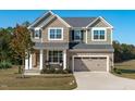 Two-story house with stone and green siding, two-car garage, and rocking chairs on the porch at 120 W. Weatherford Dr, Angier, NC 27501