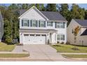 Charming two-story home featuring a two-car garage, green shutters and door, and a well-manicured lawn at 165 Tawny Slope Ct, Raleigh, NC 27603