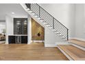 Stylish entryway features modern staircase, wet bar, wine refrigerator, and hardwood floors at 662 Manchester Dr, Raleigh, NC 27609
