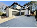 Spacious two-car garage featuring sleek, modern black doors and a durable concrete driveway at 662 Manchester Dr, Raleigh, NC 27609