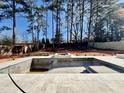Unfinished in-ground pool with tile surround and new fence in a wooded backyard at 662 Manchester Dr, Raleigh, NC 27609
