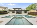 Luxurious swimming pool and hot tub with expansive patio and manicured landscaping at 662 Manchester Dr, Raleigh, NC 27609