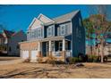 Two-story home with brick and siding exterior, two-car garage, and front porch at 454 Big Willow Way, Rolesville, NC 27571