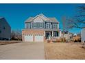 Two-story home with brick and siding exterior, two-car garage, and front porch at 454 Big Willow Way, Rolesville, NC 27571