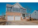 Two-story home with brick and siding exterior, two-car garage, and front porch at 454 Big Willow Way, Rolesville, NC 27571