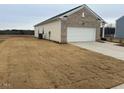 Side view of a ranch style home with a two-car garage and a large yard at 7290 Pilatus Ave, Spring Hope, NC 27882