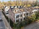 Aerial shot of townhomes with rooftop terraces and brick accents, surrounded by lush greenery at 811 Maple Berry Ln # 101, Raleigh, NC 27607