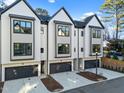 Townhome exterior showcasing attached garages, light-colored facade, black trim, and minimal landscaping at 811 Maple Berry Ln # 102, Raleigh, NC 27607