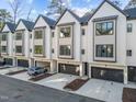 Contemporary townhome with a clean white facade, dark framed windows, and individual driveways at 811 Maple Berry Ln # 103, Raleigh, NC 27607