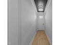 Inviting hallway with a light wood floor, white walls, and a stylish ceiling light fixture at 811 Maple Berry Ln # 103, Raleigh, NC 27607