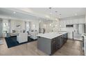 Open concept kitchen flowing into the living room, featuring a large island and stainless steel appliances at 8841 Tartan Clan Dr, Willow Springs, NC 27592