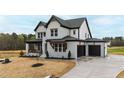 New construction home with white brick, black trim, a two-car garage and concrete driveway at 55 Firefly Ln, Louisburg, NC 27549
