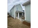 View of a light green home with a covered patio with white columns and black metal railing at 9212 Leaning Post Rd # 448, Wake Forest, NC 27587