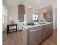 Beautiful kitchen island featuring a sink, stainless steel dishwasher, and view into the living area at 239 Harvester Rd, Angier, NC 27501