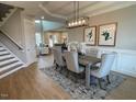 Elegant dining area with modern light fixture, stylish chairs, and hardwood floors at 274 Golden Leaf Farms Rd, Angier, NC 27501