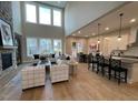 Open-concept living area with a cozy fireplace, large windows, and views of the kitchen at 274 Golden Leaf Farms Rd, Angier, NC 27501